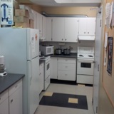 A complete kitchen, with fridge, stove, microwave, and coffee pot.